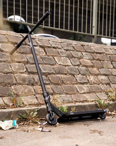 CORE ST2 Stunt Scooter Black I Adult Stunt Scooter Leaning Wall