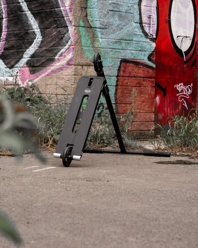 CORE ST2 Stunt Scooter Black I Adult Stunt Scooter Leaning by Wall